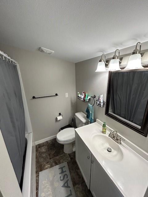 full bathroom featuring vanity, shower / bath combination with curtain, toilet, and a textured ceiling