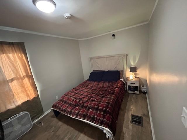 bedroom with crown molding and hardwood / wood-style flooring