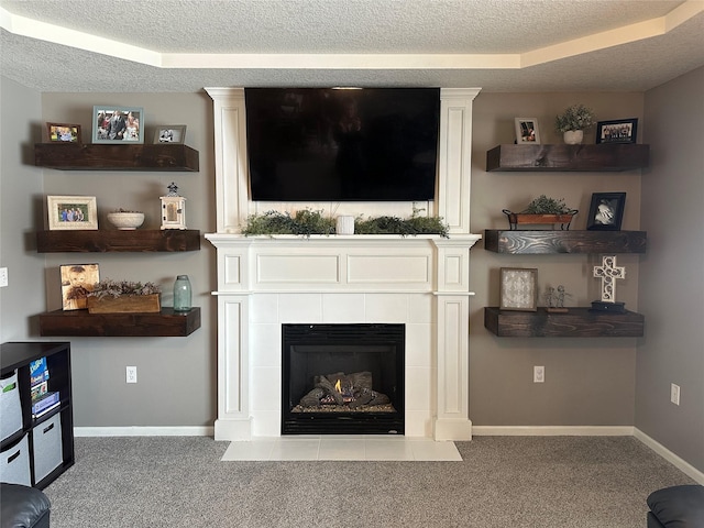 carpeted living room featuring a textured ceiling and a tiled fireplace