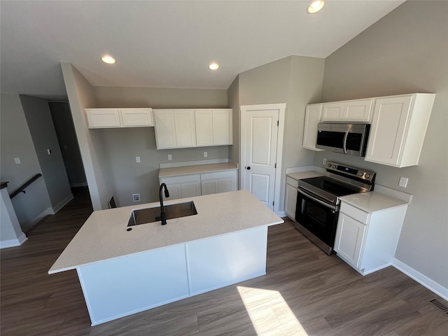 kitchen with appliances with stainless steel finishes, dark hardwood / wood-style floors, white cabinetry, sink, and a center island with sink