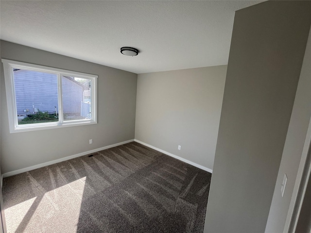 empty room with dark colored carpet