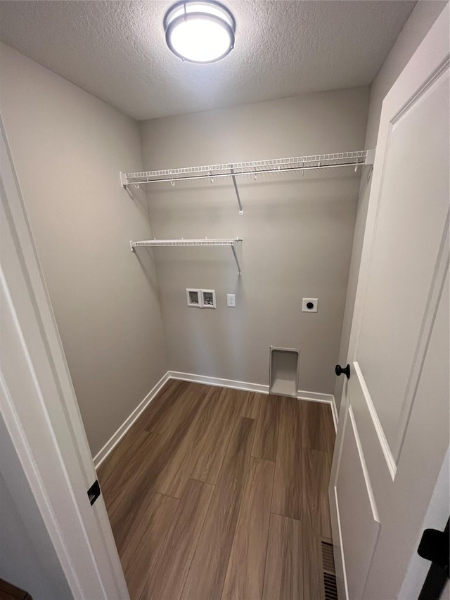 clothes washing area featuring washer hookup, dark hardwood / wood-style flooring, hookup for an electric dryer, and a textured ceiling