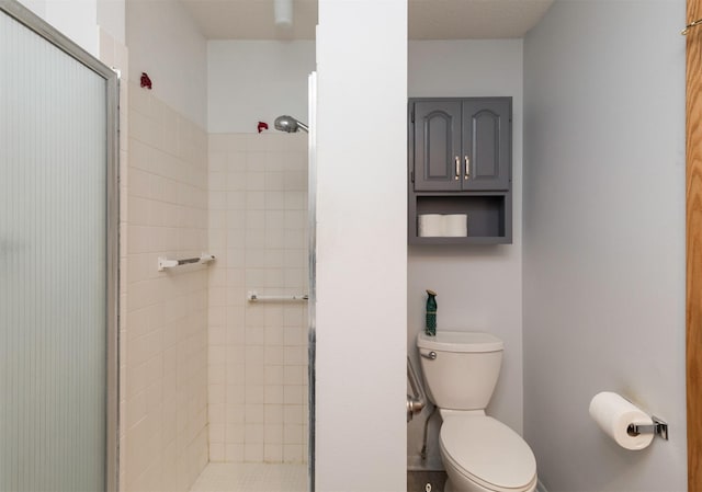 bathroom featuring toilet and a tile shower