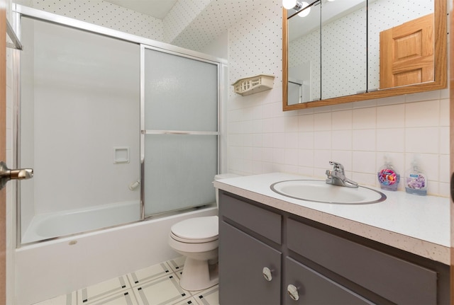 full bathroom featuring backsplash, bath / shower combo with glass door, toilet, vanity, and tile walls