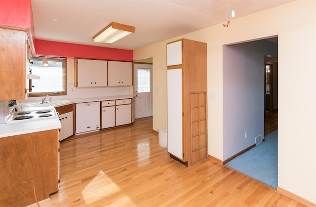 kitchen with white cabinets, white appliances, and a wealth of natural light