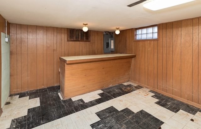 bar featuring electric panel and wooden walls