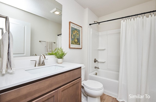 full bathroom featuring wood-type flooring, vanity, toilet, a textured ceiling, and shower / bath combo with shower curtain