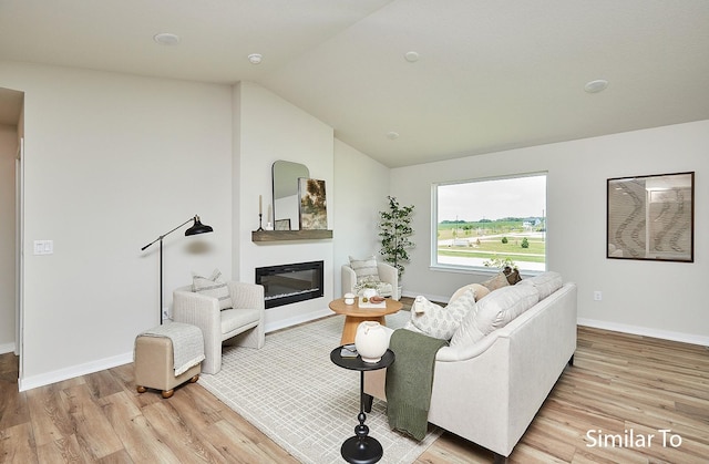 living room featuring lofted ceiling and light wood-type flooring