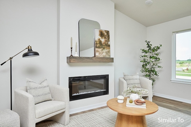 sitting room with wood-type flooring and vaulted ceiling