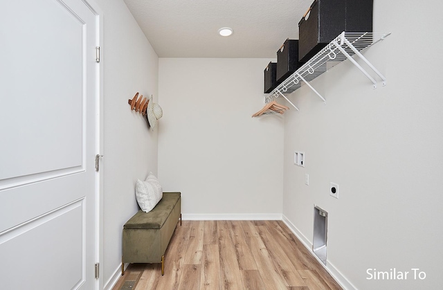 washroom featuring hookup for a washing machine, light hardwood / wood-style flooring, and electric dryer hookup