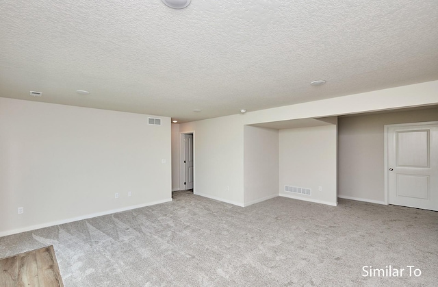 empty room featuring light carpet and a textured ceiling