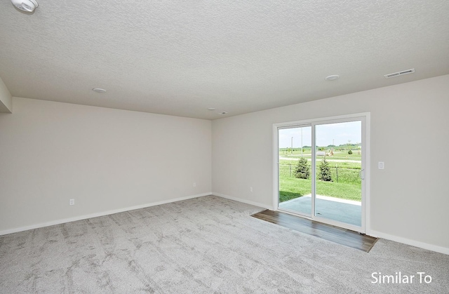 empty room featuring carpet flooring and a textured ceiling