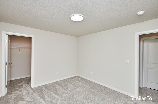 unfurnished bedroom featuring a spacious closet, light colored carpet, and a closet