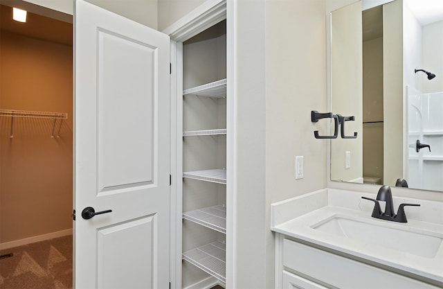 1064 NE 64th Ave, Des Moines, IA 50313 - bathroom with vanity, baseboards, and a spacious closet