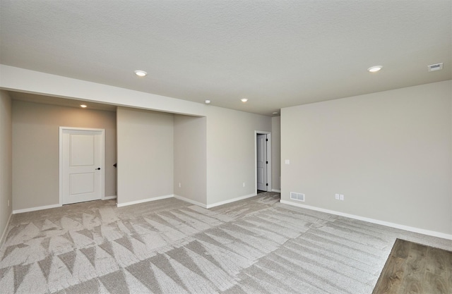 unfurnished room with visible vents, recessed lighting, baseboards, and light carpet