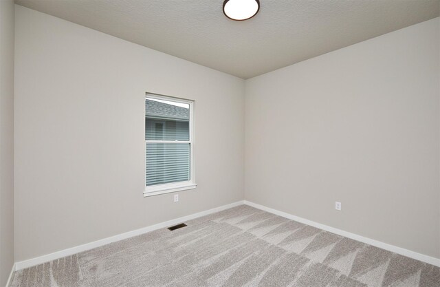 unfurnished room featuring visible vents, carpet flooring, and baseboards