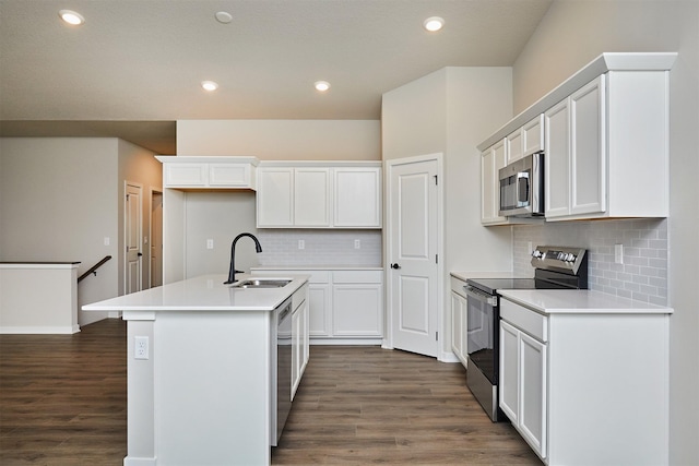 kitchen featuring a sink, dark wood finished floors, a center island with sink, and stainless steel appliances