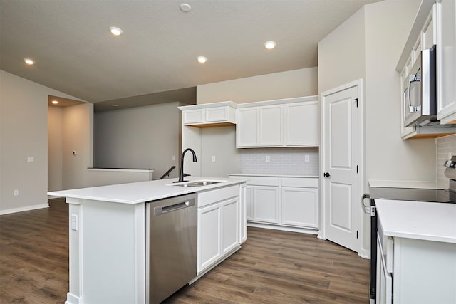 kitchen featuring appliances with stainless steel finishes, tasteful backsplash, a sink, and dark wood-type flooring
