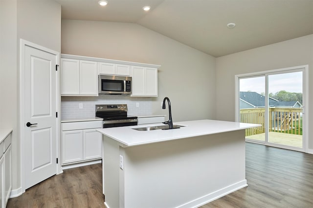 kitchen with backsplash, appliances with stainless steel finishes, a sink, dark wood-style floors, and lofted ceiling