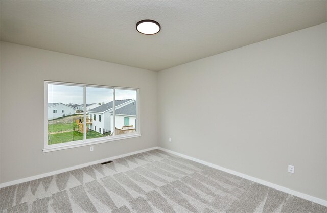 1064 NE 64th Ave, Des Moines, IA 50313 - spare room featuring baseboards, visible vents, and light colored carpet