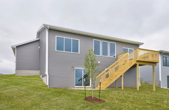 back of house featuring stairway, a lawn, and a wooden deck