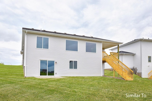 rear view of property with a yard and central air condition unit