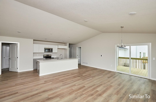 kitchen featuring decorative light fixtures, an island with sink, sink, white cabinets, and stainless steel appliances