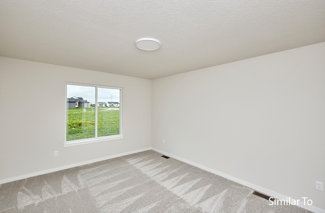 unfurnished room featuring carpet flooring and a textured ceiling