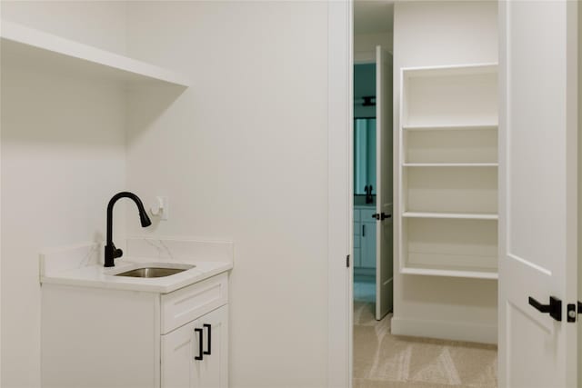 interior space with sink and light colored carpet