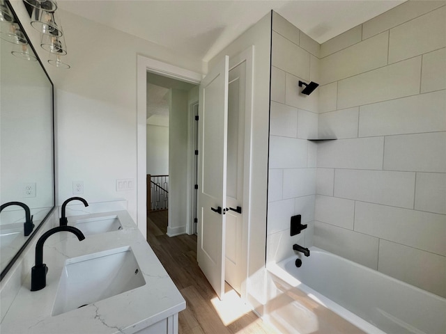 bathroom featuring vanity, wood-type flooring, and tiled shower / bath