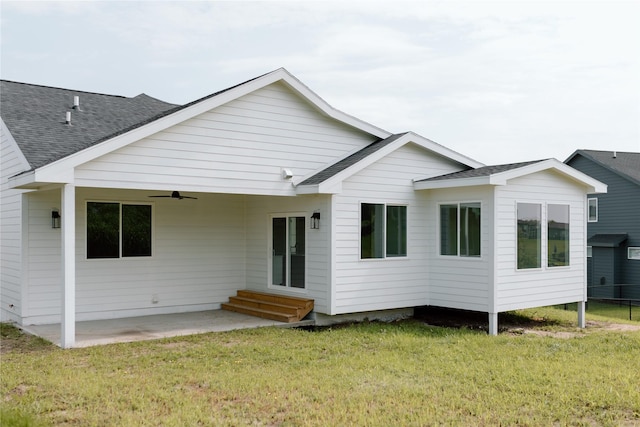 back of property with a yard, ceiling fan, and a patio area