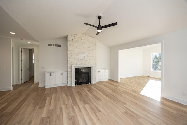 unfurnished living room with ceiling fan, light wood-type flooring, a fireplace, and vaulted ceiling