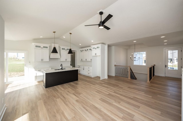 kitchen featuring white cabinets, light hardwood / wood-style floors, a wealth of natural light, and an island with sink