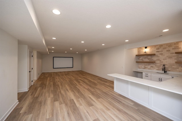 unfurnished living room with sink and light hardwood / wood-style flooring