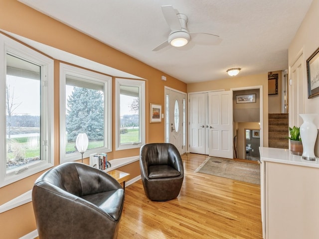 sitting room with ceiling fan, light hardwood / wood-style flooring, and a healthy amount of sunlight