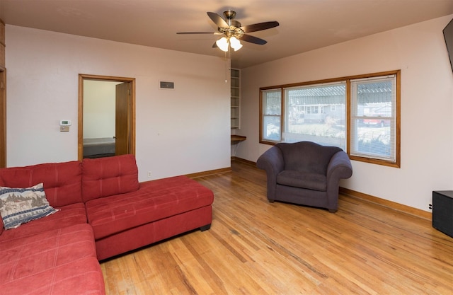 living room with ceiling fan and light hardwood / wood-style flooring