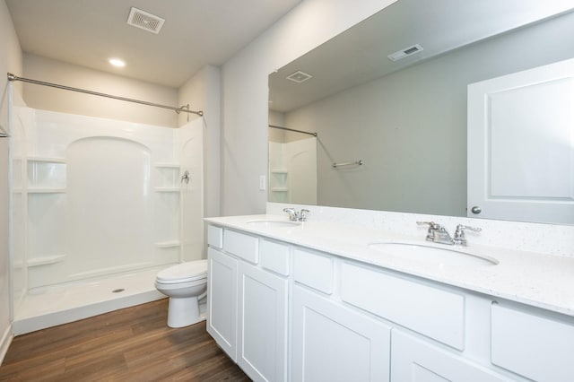 bathroom with toilet, a shower, wood-type flooring, and vanity