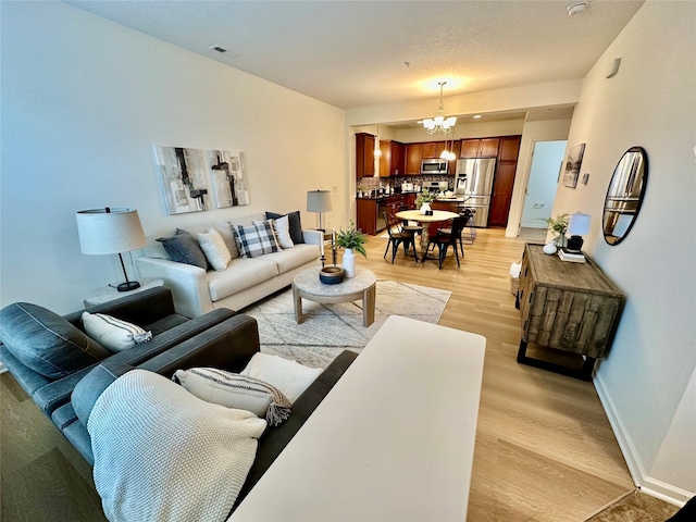 living room with a chandelier and light hardwood / wood-style flooring