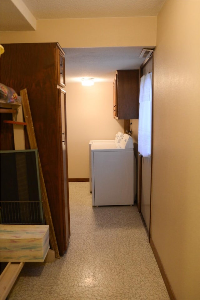 washroom with cabinets and washing machine and dryer