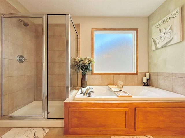 bathroom with tile patterned flooring and shower with separate bathtub