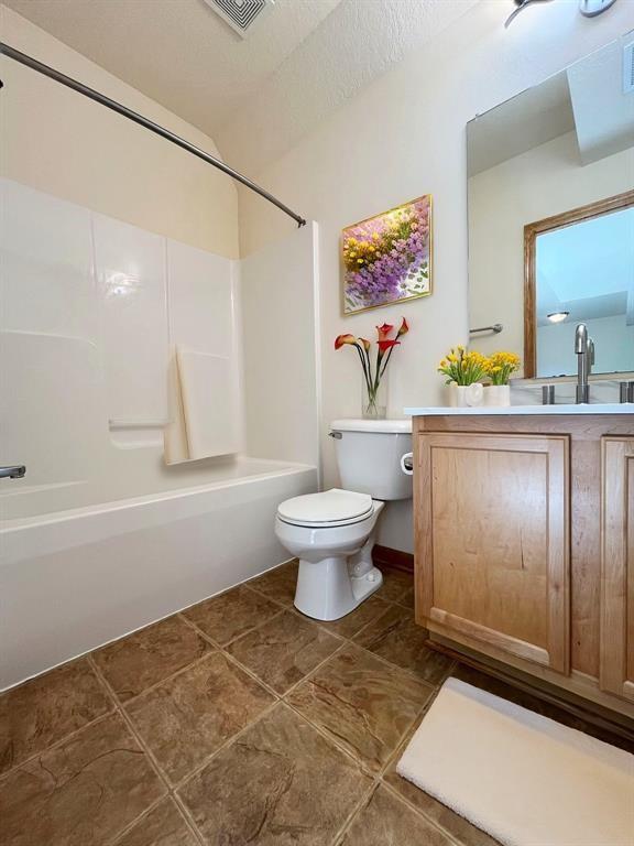 full bathroom with tile patterned floors, vanity, shower / bath combination, and toilet