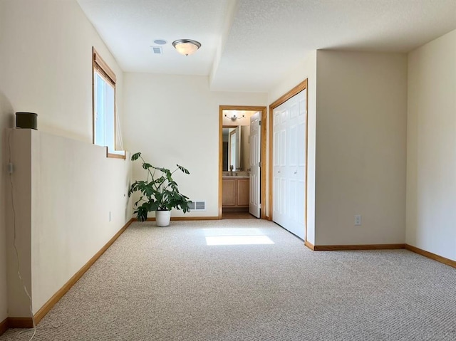 carpeted spare room featuring a textured ceiling