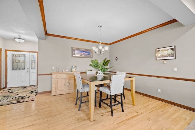 dining space featuring light wood-type flooring, crown molding, and an inviting chandelier