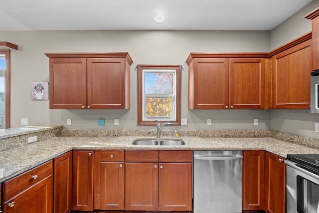 kitchen featuring sink, light stone countertops, and stainless steel appliances