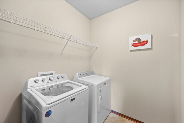 clothes washing area featuring a textured ceiling and washer and clothes dryer