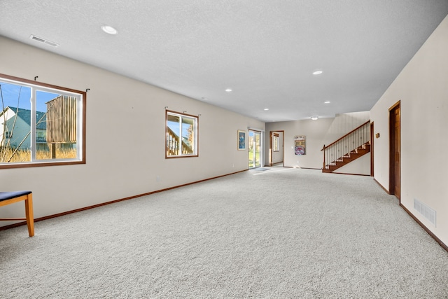 unfurnished living room with a wealth of natural light and carpet