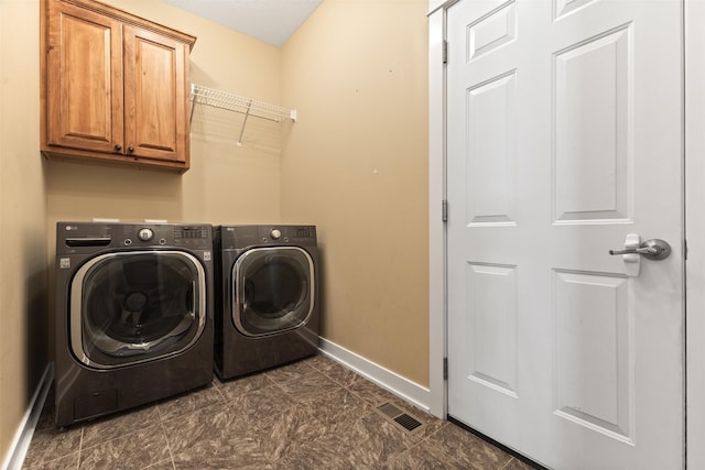 laundry room featuring cabinets and washing machine and dryer