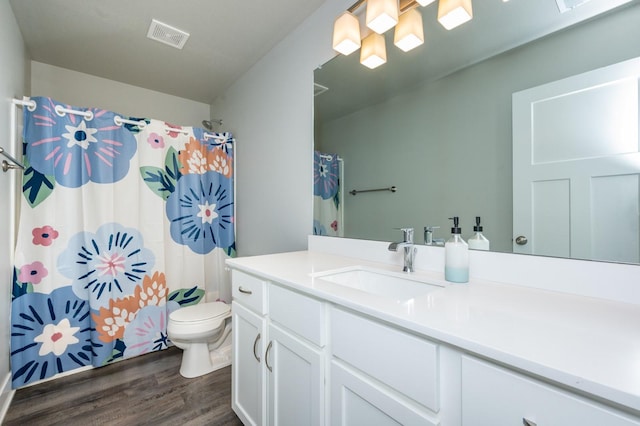 bathroom featuring vanity, hardwood / wood-style flooring, toilet, and walk in shower