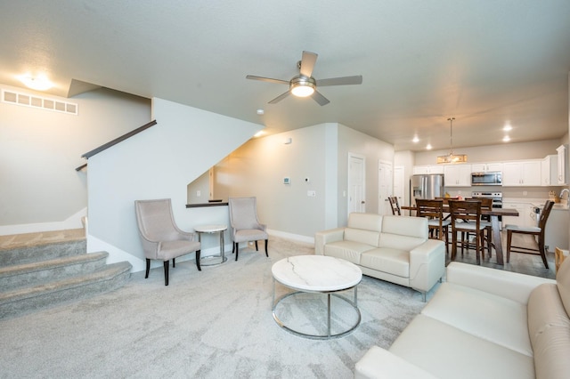 carpeted living room with ceiling fan