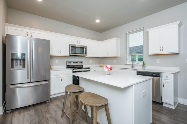 kitchen featuring a center island, sink, stainless steel appliances, dark hardwood / wood-style flooring, and white cabinets